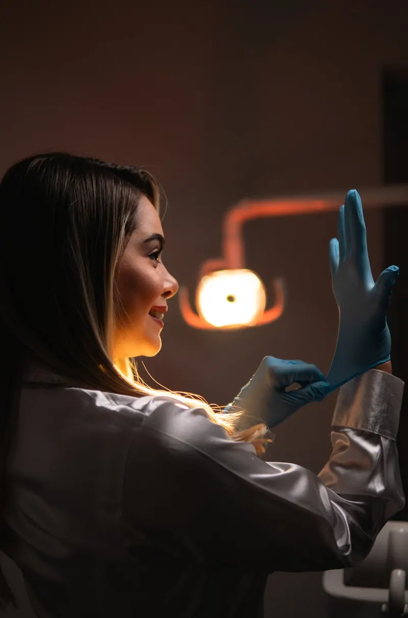 Cirumax specialist putting on gloves under the clinic lamp